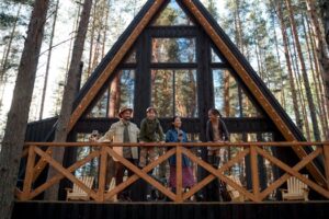 A family enjoys their vacation at a modern A-frame cabin nestled in a peaceful forest setting.